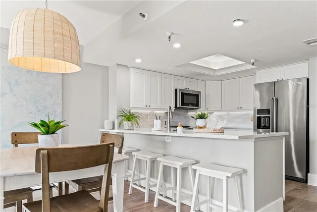 a kitchen with a table chairs refrigerator and microwave
