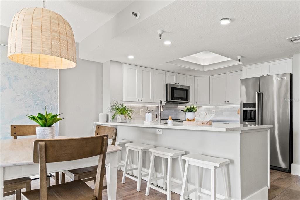 6035 Sea Ranch Drive, Unit 203 Hudson, FL 34667 - Photo 8 of 55 a kitchen with a table chairs refrigerator and microwave