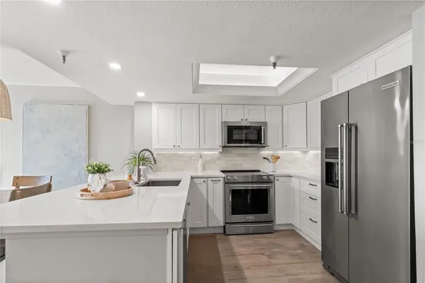a kitchen with stainless steel appliances a sink stove and refrigerator