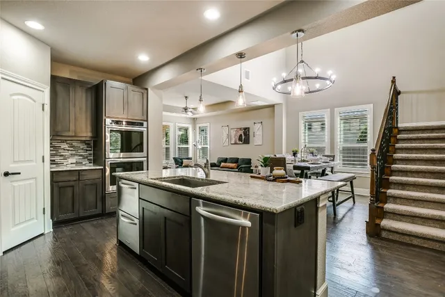 a kitchen with stainless steel appliances granite countertop a sink stove and refrigerator