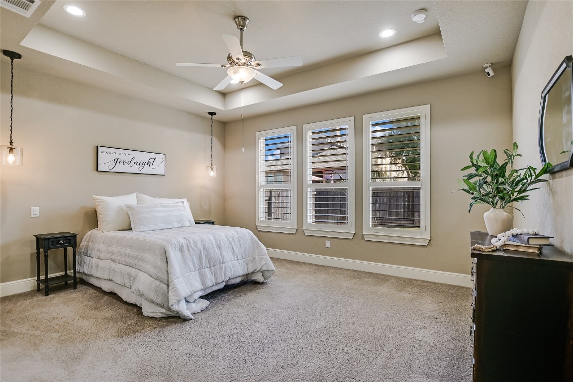 416 Cherokee Rose Circle Georgetown, TX 78626 - Photo 7 of 36 a spacious bedroom with a bed and a chandelier