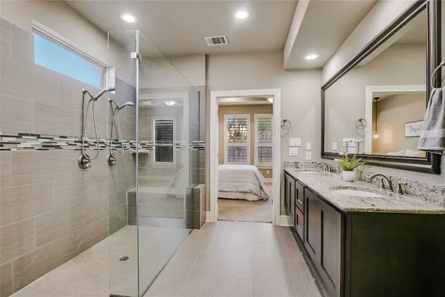 a bathroom with a double vanity sink a mirror and shower