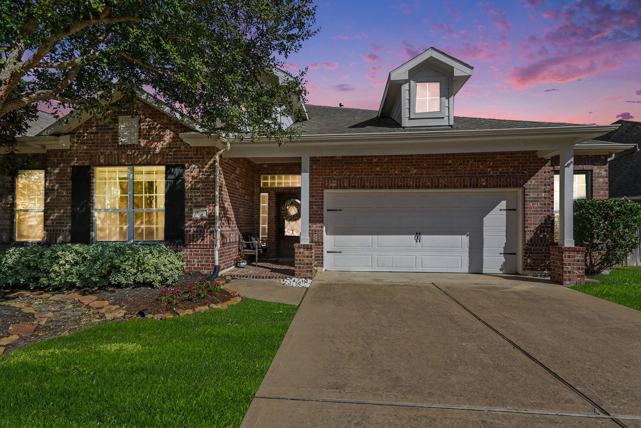 27006 Cliff Pointe Lane Katy, TX 77494 - Photo 2 of 34 A picture-perfect first impression, this charming brick exterior shines at sunset with mature trees, manicured landscaping, and inviting curb appeal that instantly feels like home.