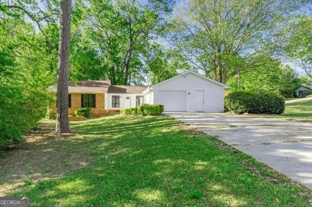 a front view of a house with a yard and trees