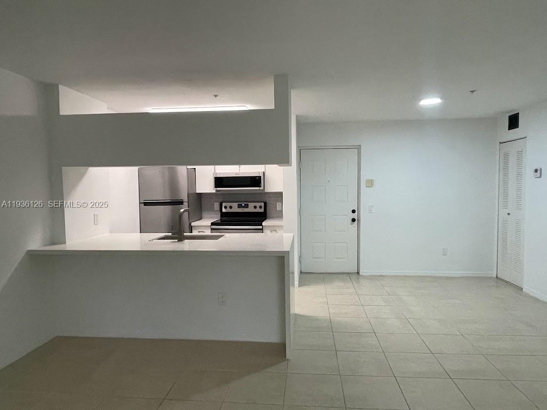 430 South Park Road, Unit 3305 Hollywood, FL 33021 - Photo 3 of 27 a kitchen with stainless steel appliances a refrigerator and a stove top oven