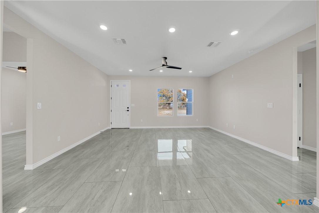 816 County Road, Unit 6723 Natalia, TX 78059 - Photo 4 of 19 an empty room with wooden floor and windows