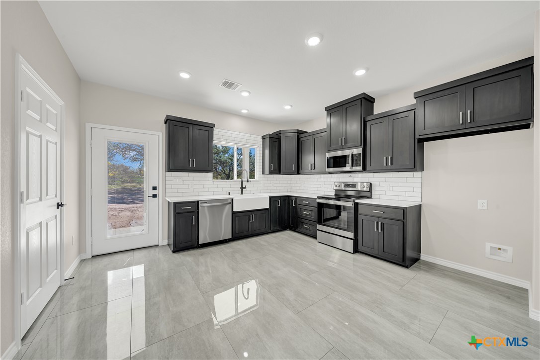 816 County Road, Unit 6723 Natalia, TX 78059 - Photo 6 of 19 a large kitchen with stainless steel appliances and a sink