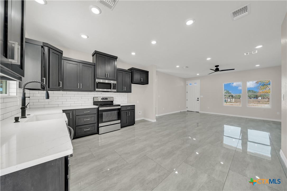 816 County Road, Unit 6723 Natalia, TX 78059 - Photo 8 of 19 a large kitchen with stainless steel appliances a large counter top a stove a sink and a refrigerator