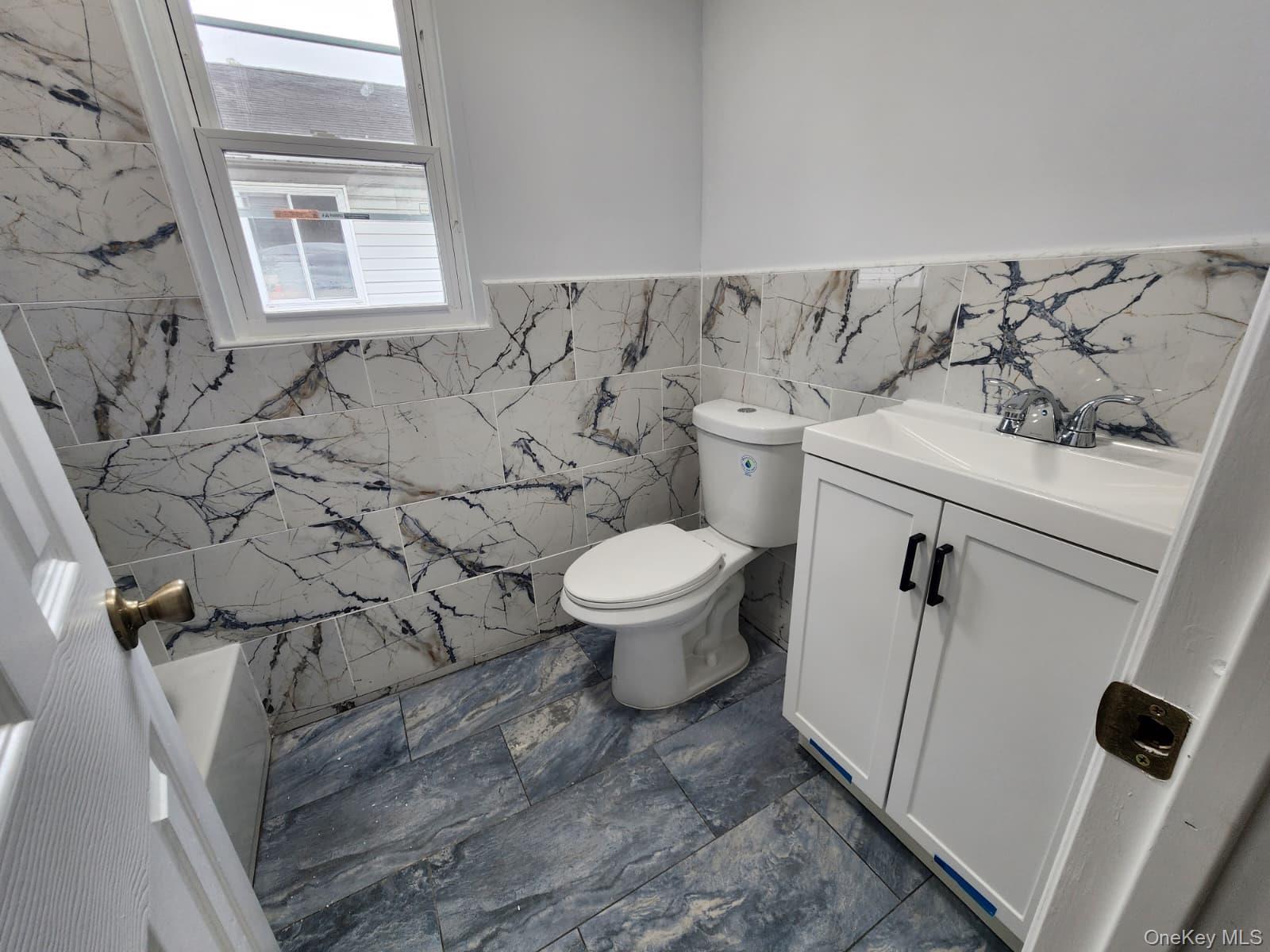 221-26 134th Road Queens, NY 11413 - Photo 18 of 30 a bathroom with a toilet and a sink