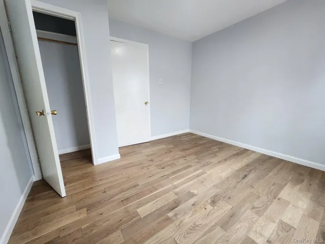 an empty room with wooden floor and entrance