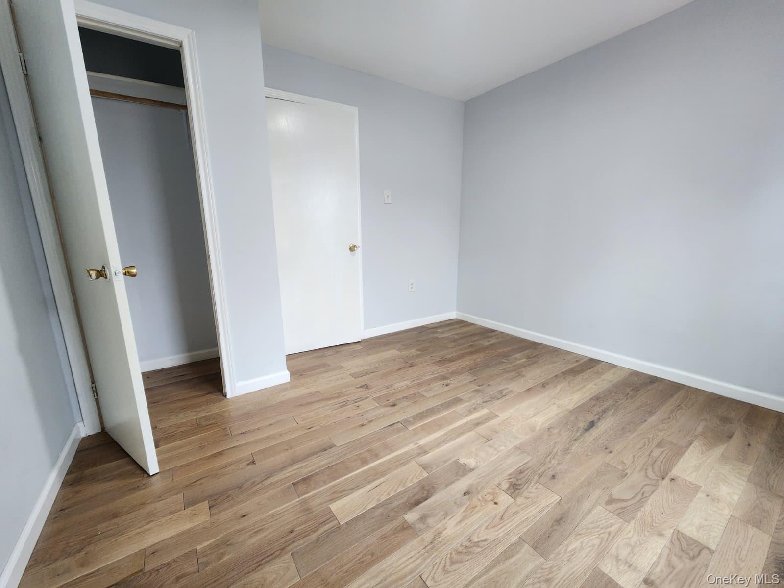 221-26 134th Road Queens, NY 11413 - Photo 23 of 30 an empty room with wooden floor and entrance