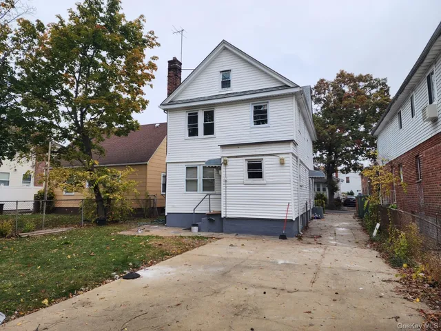 a white house covered with tall trees