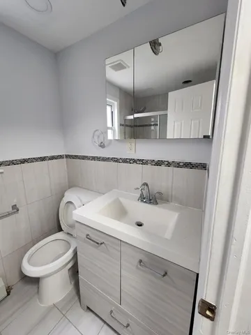 a bathroom with a sink a toilet and mirror