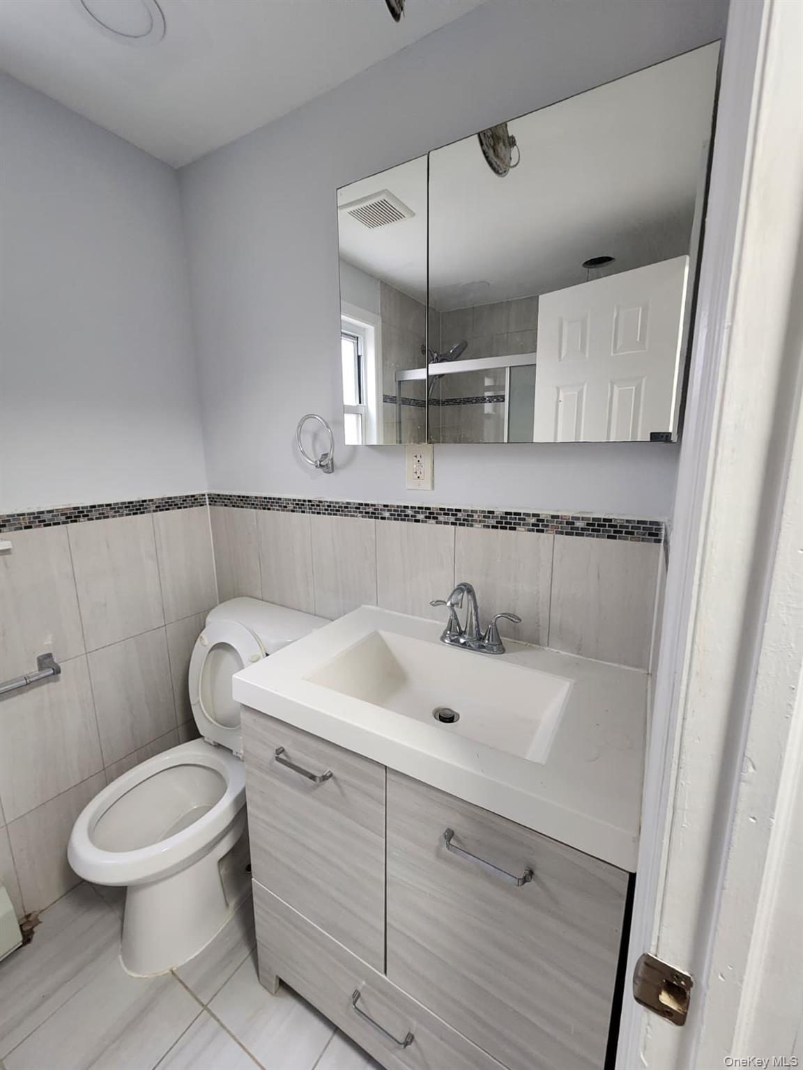 221-26 134th Road Queens, NY 11413 - Photo 8 of 30 a bathroom with a sink a toilet and mirror