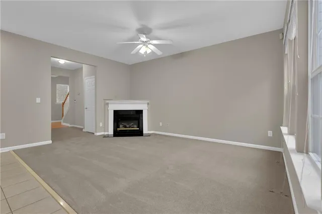 an empty room with fireplace and fan