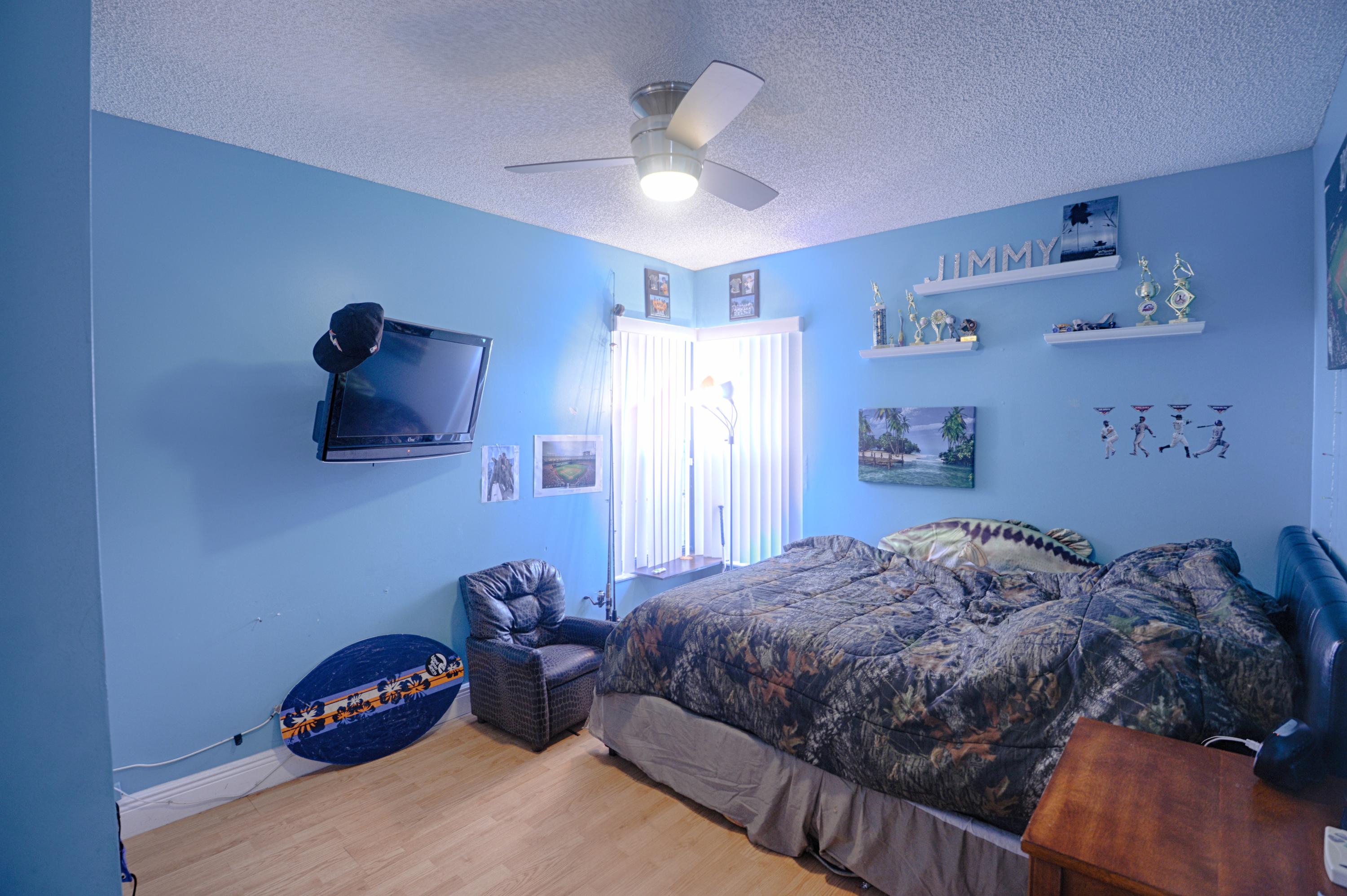 11885 Sunchase Court Boca Raton, FL 33498 - Photo 12 of 25 a bedroom with a bed and a chandelier