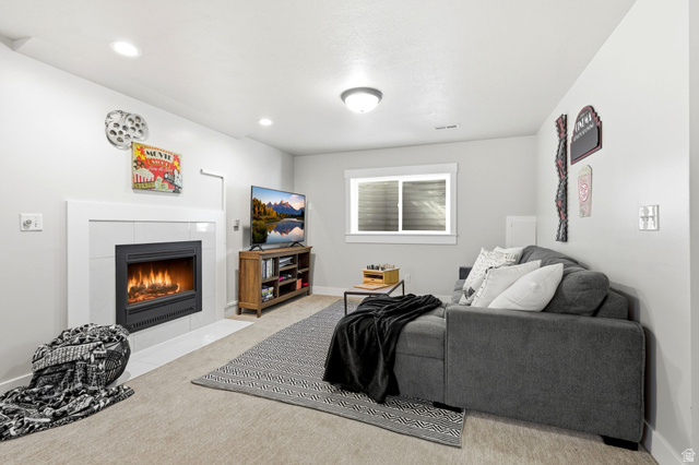 1405 Vintry Lane Murray, UT 84121 - Photo 24 of 44 Living area featuring a fireplace with a white tile surround, recessed lighting, and a single window with blinds