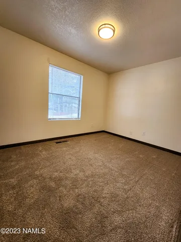 an empty room with a projector and a window