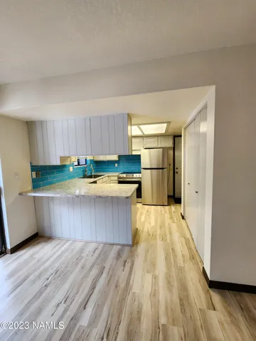 a view of kitchen with wooden floor and electronic appliances