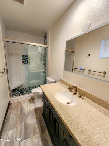 a bathroom with a sink a toilet and shower
