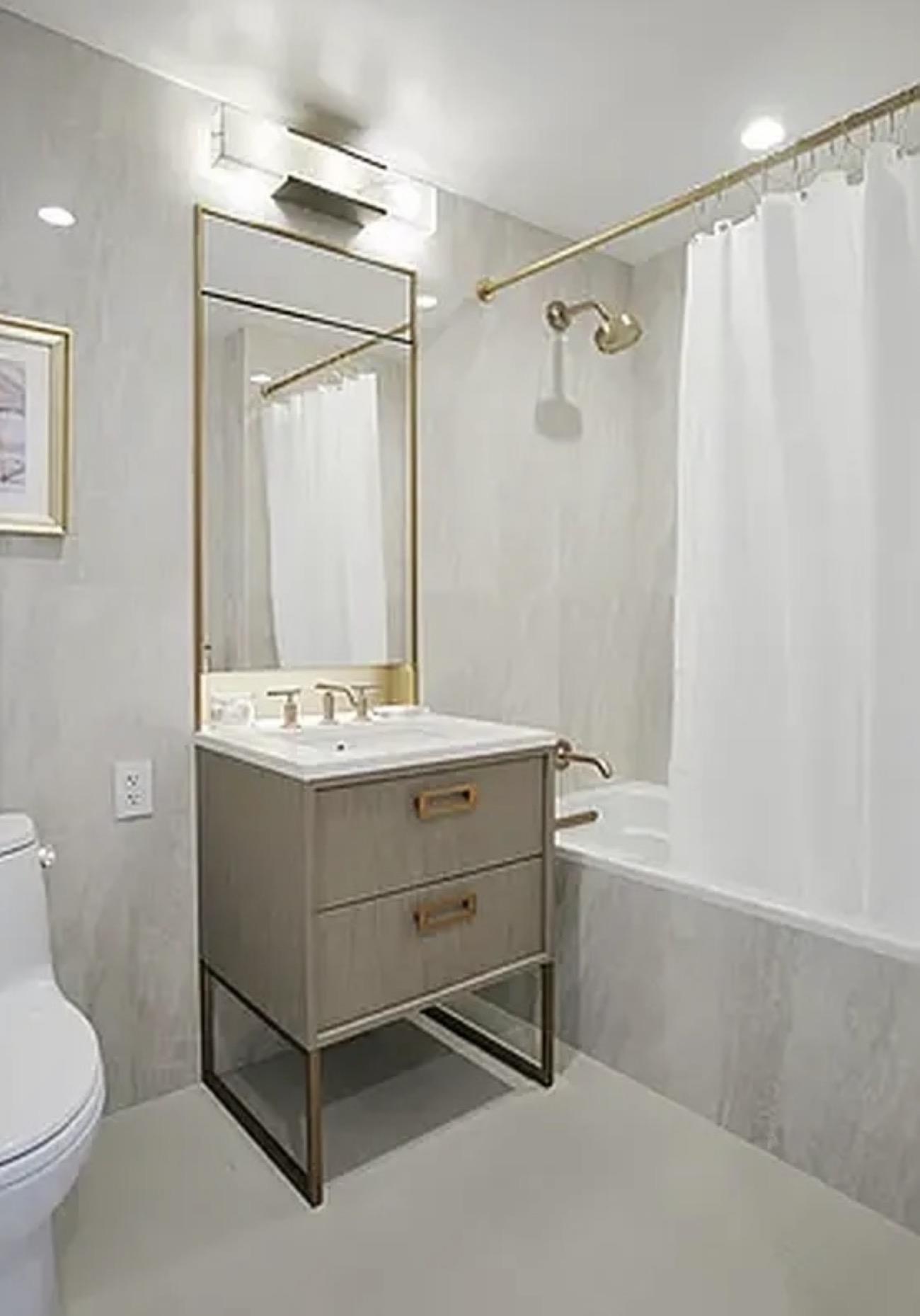 3 Court Square, Unit 4702 Queens, NY 11101 - Photo 4 of 5 a bathroom with a sink mirror vanity and toilet