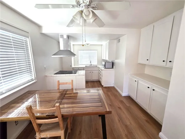 a kitchen with a table chairs window and cabinets
