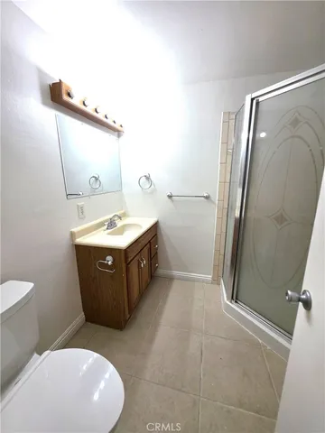 a bathroom with a granite countertop sink mirror vanity and toilet