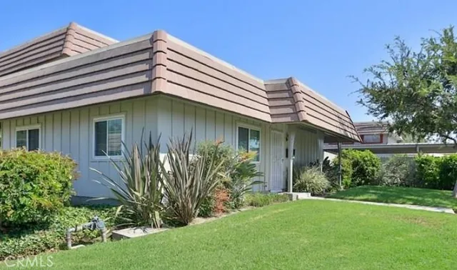 a view of a house with brick walls and a small yard