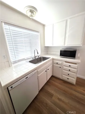 a kitchen with cabinets appliances a sink and a window
