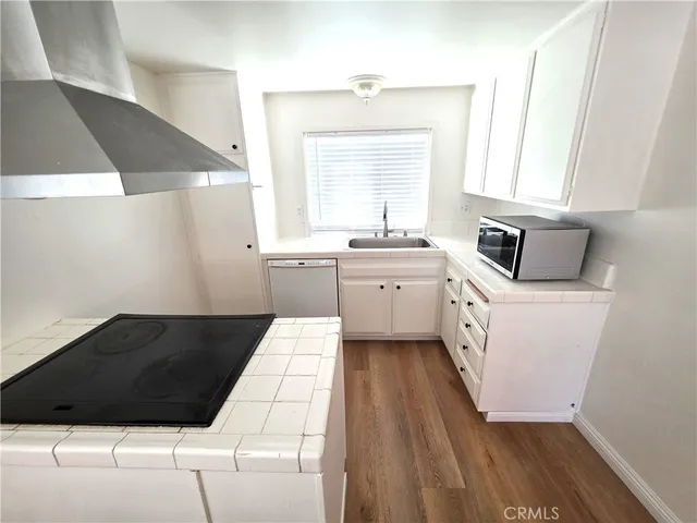 a kitchen with a sink a window and cabinets