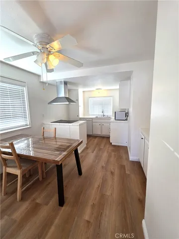 a living room with a table chairs and a kitchen view