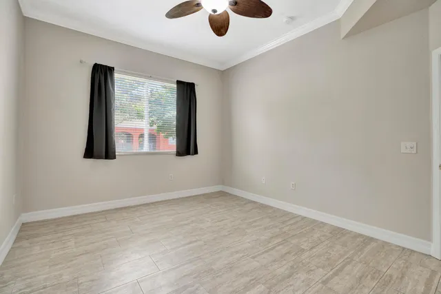 an empty room with a window and a ceiling fan