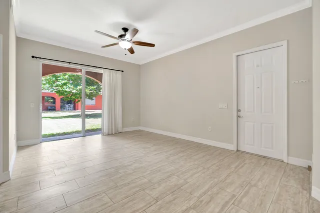 a view of empty room with wooden floor and fan