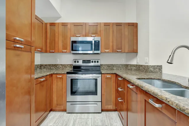 a kitchen with stainless steel appliances granite countertop a sink stove and microwave