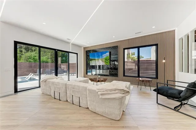 a living room with stainless steel appliances kitchen island granite countertop a sink and cabinets
