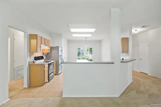a living room with stainless steel appliances granite countertop furniture and a kitchen view