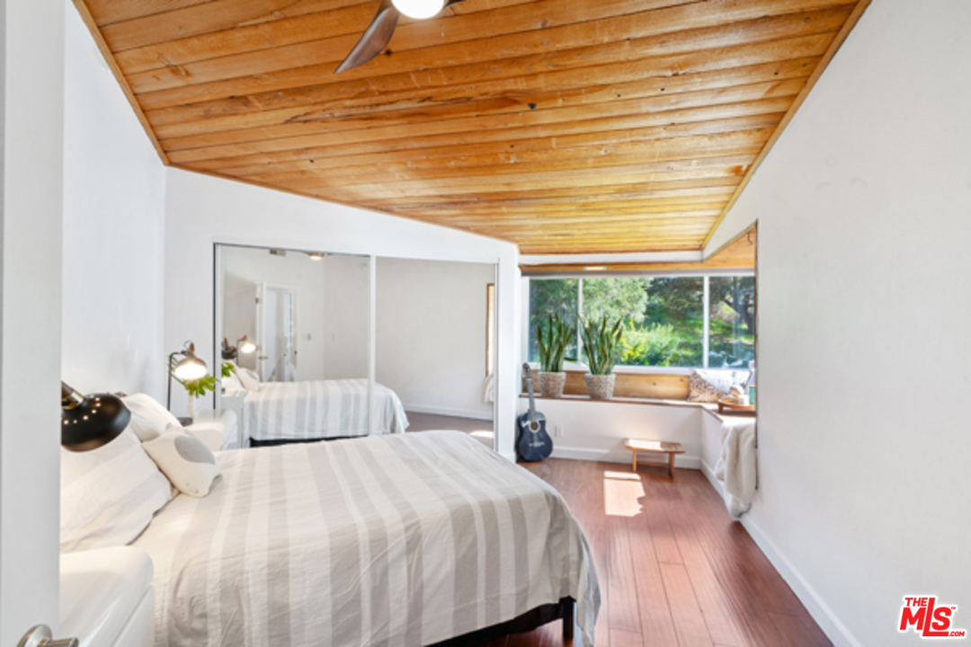 1580 Las Virgenes Road Calabasas, CA 91302 - Photo 24 of 51 a bedroom with a bed and wooden floor