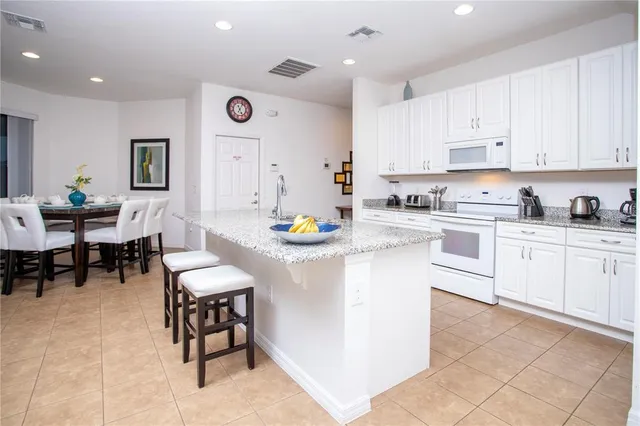 a kitchen with cabinets and chairs in it