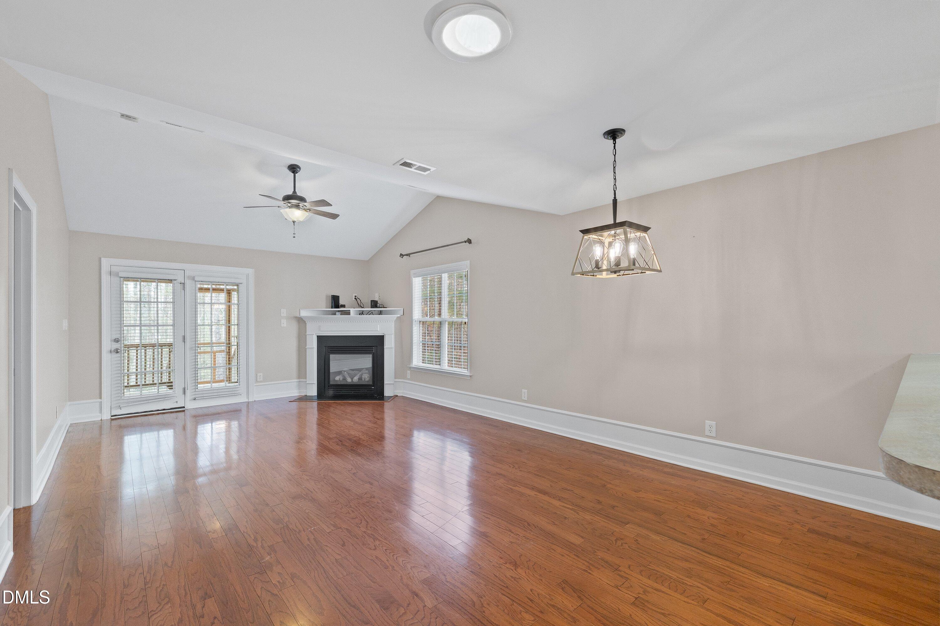 3666 East Cotton Gin Drive Clayton, NC 27527 - Photo 12 of 33 a view of a room with wooden floor fireplace and windows
