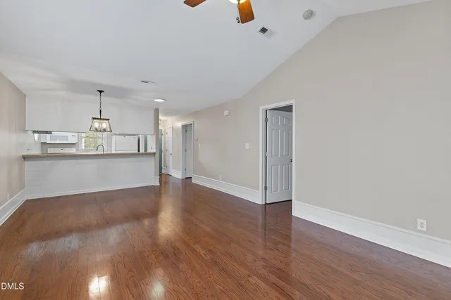 a view of a kitchen with wooden floor and cabinets