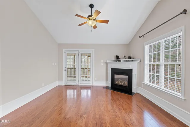 wooden floor fireplace and windows in an empty room