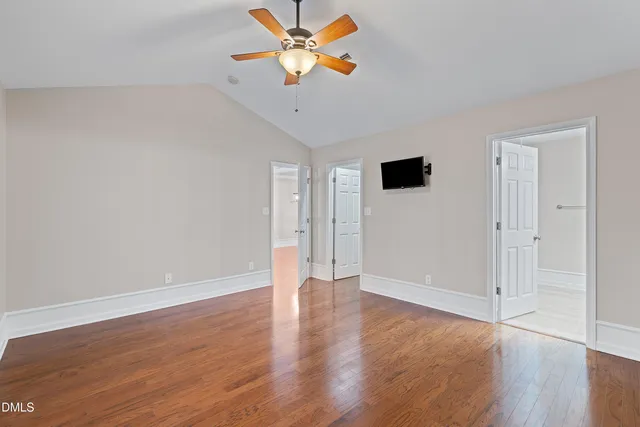 a view of an empty room with wooden floor