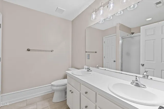 a bathroom with a toilet a sink a mirror and a shower