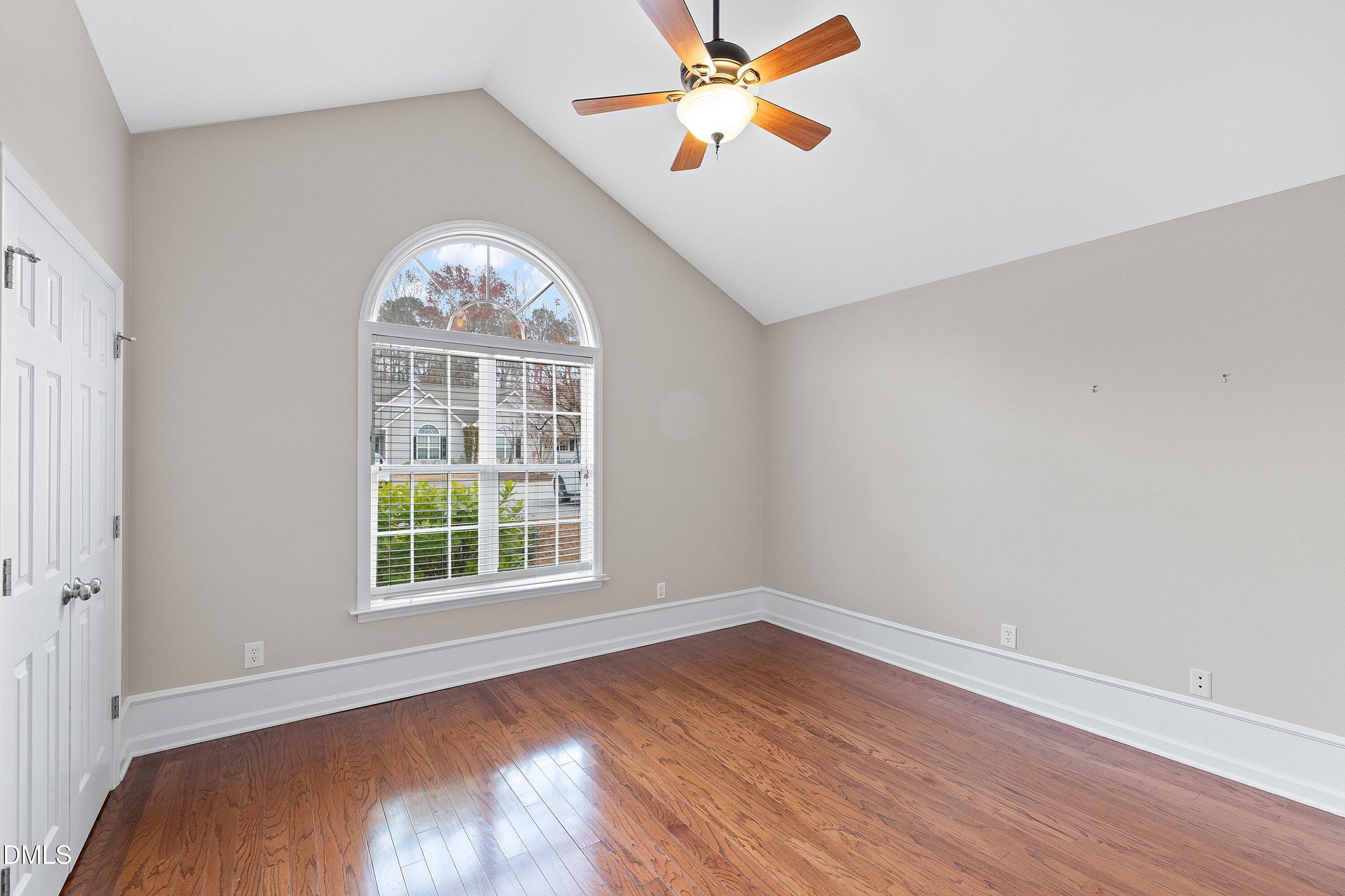3666 East Cotton Gin Drive Clayton, NC 27527 - Photo 27 of 33 an empty room with wooden floor chandelier fan and windows