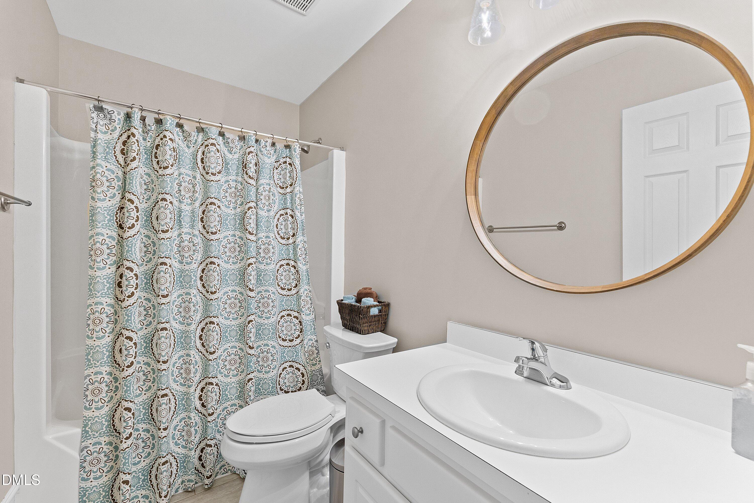 3666 East Cotton Gin Drive Clayton, NC 27527 - Photo 29 of 33 a bathroom with a sink a toilet and a mirror
