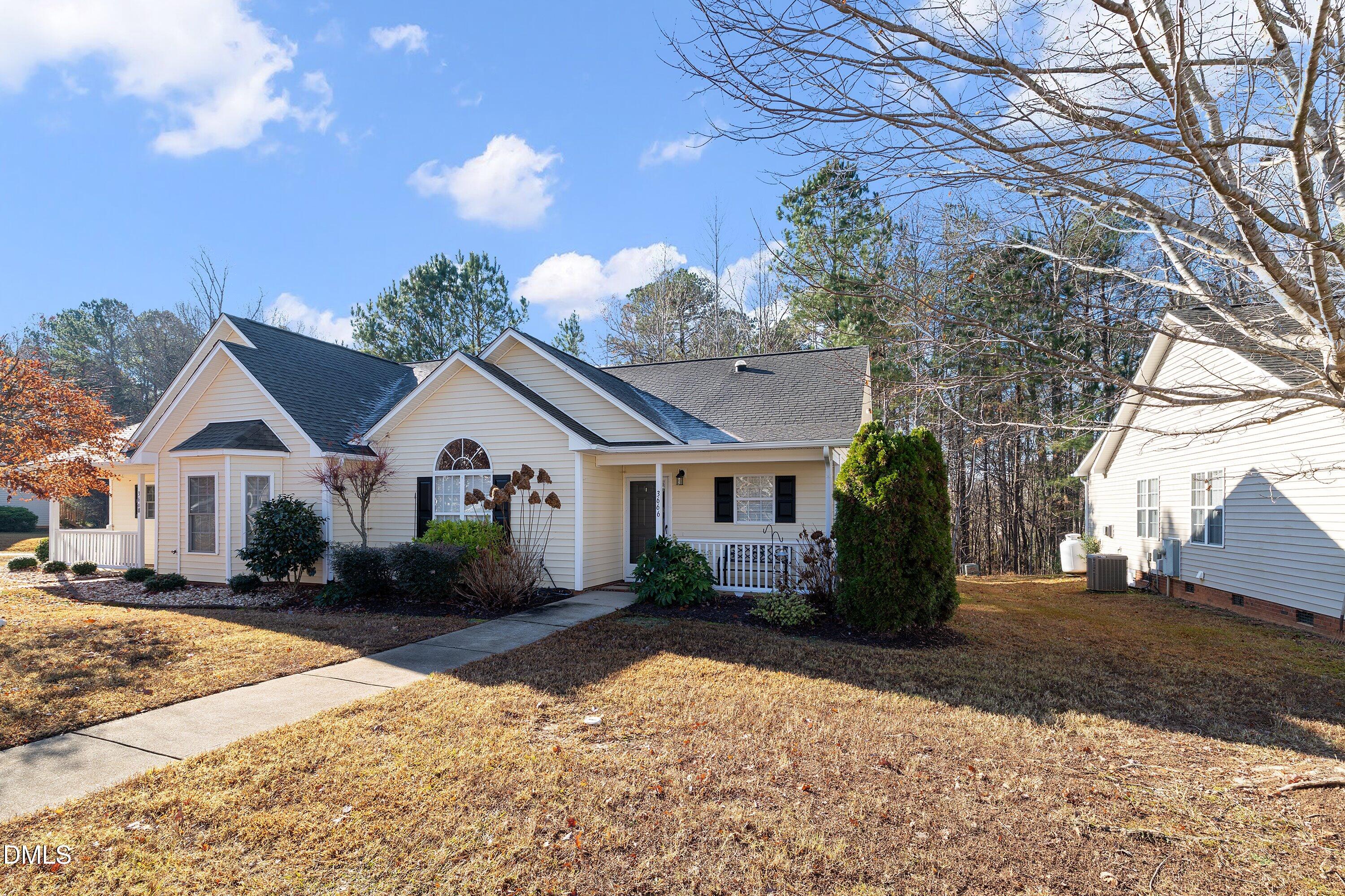 3666 East Cotton Gin Drive Clayton, NC 27527 - Photo 3 of 33 a front view of a house with a yard and potted plants