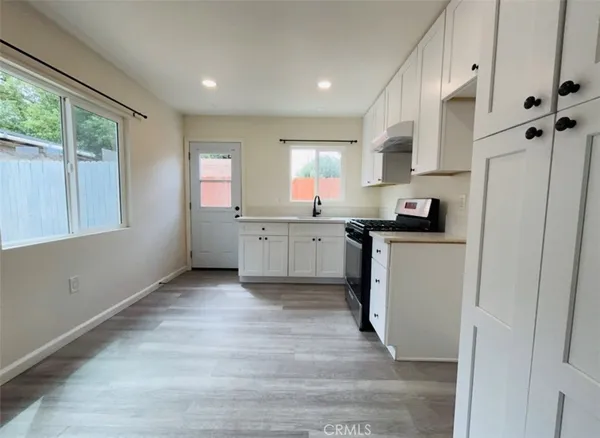 a kitchen with stainless steel appliances granite countertop a stove a sink and a refrigerator