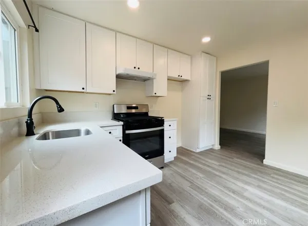 a kitchen with granite countertop white cabinets and stainless steel appliances