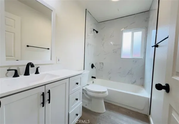 a bathroom with a tub sink toilet and mirror