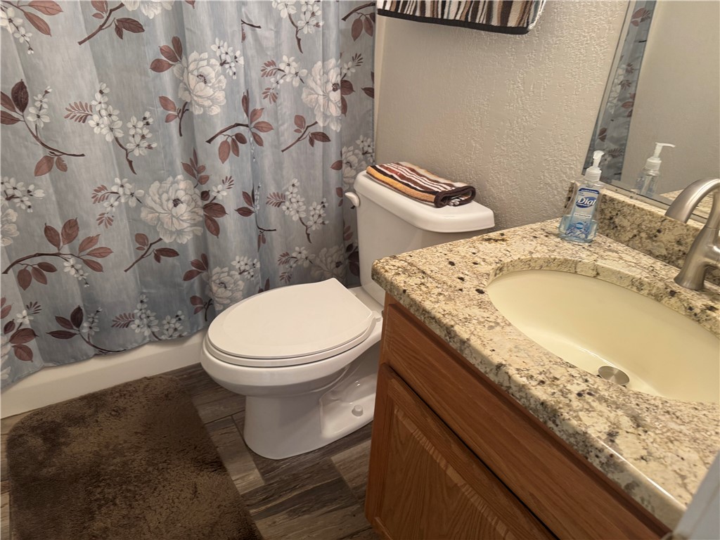 95 Deer Run Road Delaware, AR 72835 - Photo 21 of 40 Bathroom featuring a vanity with a light-toned countertop, an undermount sink, a chrome faucet, and wood-finish cabinetry